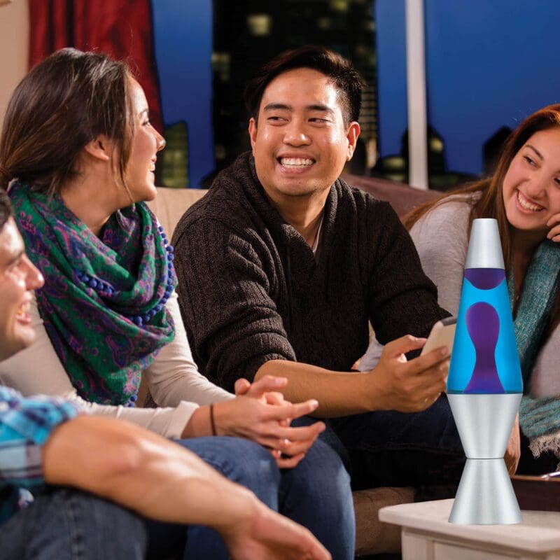 21180401US-LavaLamp-14-5-Purple-and-Blue-Lifestyle3-web 14.5” LAVA® Lamp – Purple/Blue/Silver on a coffee table at a party
